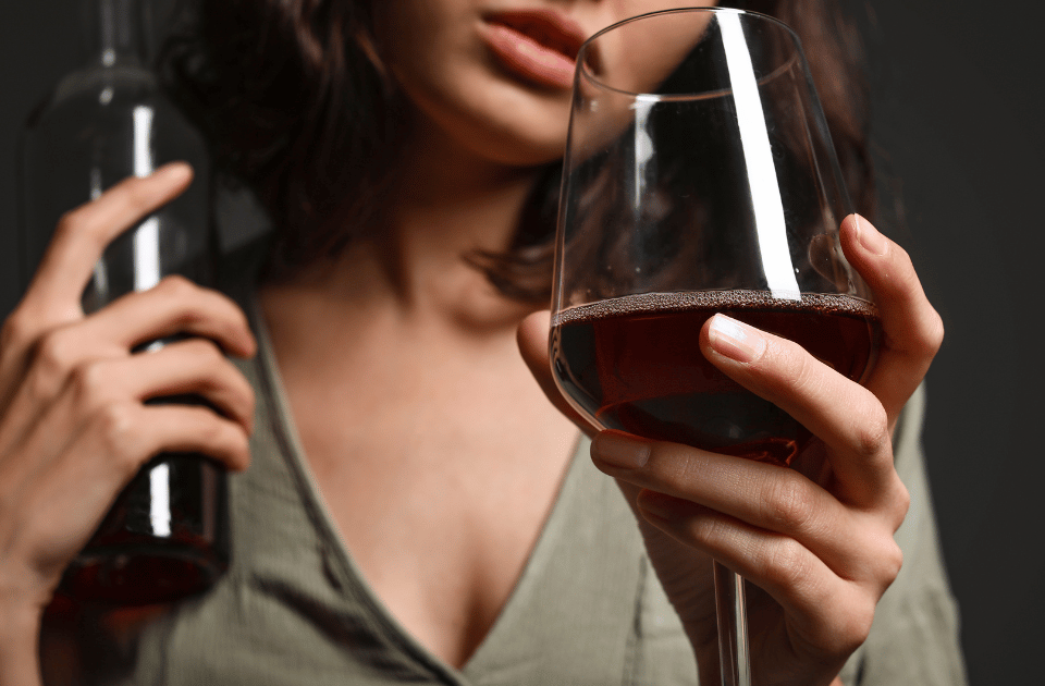 Mujer con una botella y una copa de vino